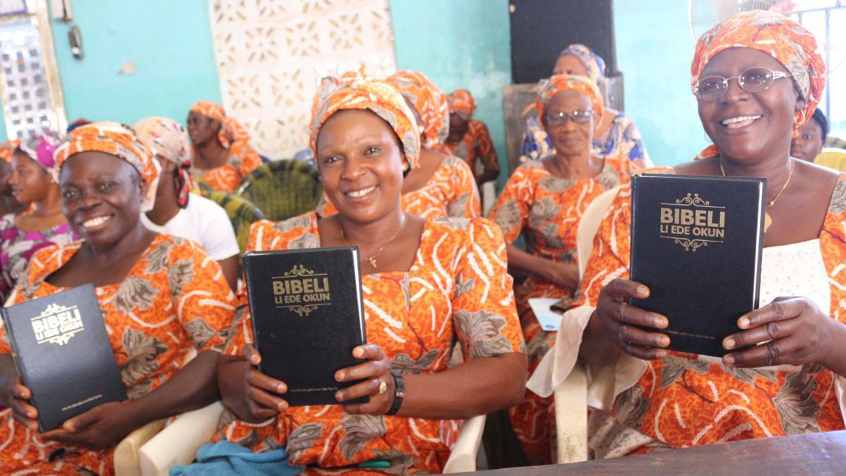 Frauen in nigerianischer Tracht freuen sich über die Vollbibel in ihrer Muttersprache Okun