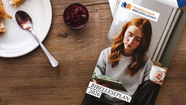 Auf dem Cover des Bibelleseplans ist folgendes zu sehen: Person mit roten Haaren hält eine weiße Tasse und ein Buch. Danzu die Aufschrift 'BIBELLESEPLAN 2026' und dem Logo der Österreichischen Bibelgesellschaft.