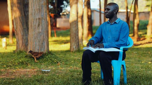 Patrick Owiyo liest in einem Band der Braille-Bibel in Acholi. Für diese Braille-Bibel in seiner Sprache hat er gekämpft - und jetzt bereitet er sich darauf vor, Pfarrer zu werden.  Patrick Owiyo liest in einem Band der Braille-Bibel in Acholi. Für diese Braille-Bibel in seiner Sprache hat er gekämpft - und jetzt bereitet er sich darauf vor, Pfarrer zu werden.